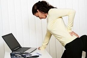 a woman with back pain in the lumbar region