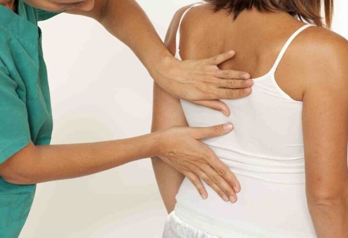 Doctor examines back with shoulder pain